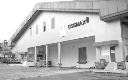 Black-and-white exterior view of COSMAX Indonesia factory