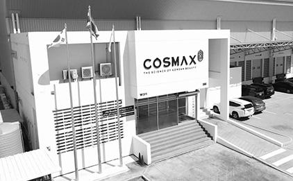 Black-and-white COSMAX Thailand factory with Thai and Korean flags, parking lot on right
